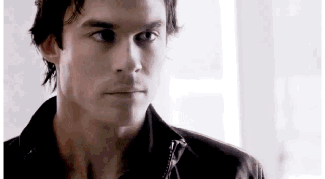 a close up of a man 's face wearing a leather jacket .