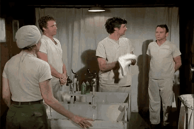 a group of men are standing around a table in a room .
