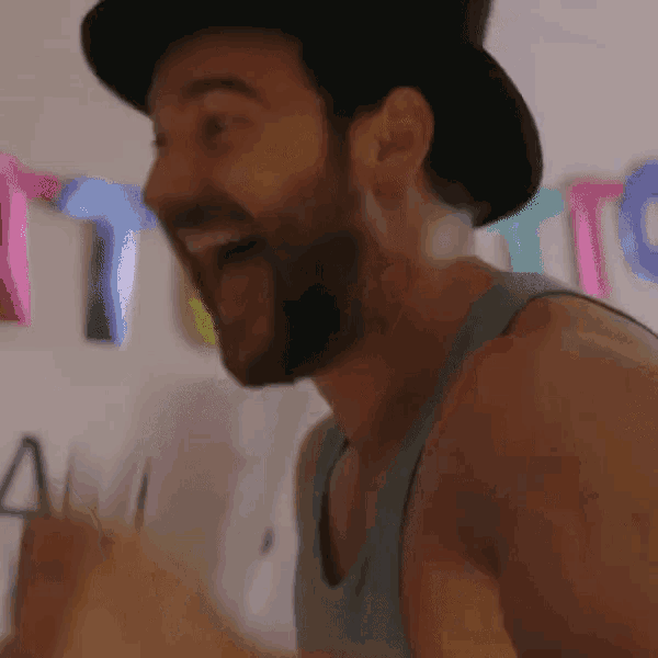 a man with a beard wearing a top hat is laughing
