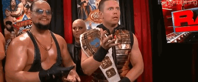 a group of wrestlers are standing next to each other in front of a red curtain