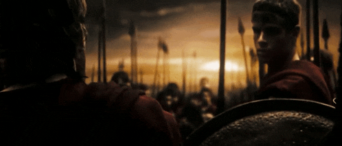 a man in a red shirt is standing in front of a crowd of soldiers