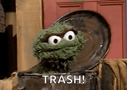 oscar the grouch from sesame street is sitting in a trash can with the word trash written on it .