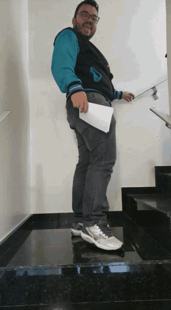 a man standing on a set of stairs holding a piece of paper in his pocket