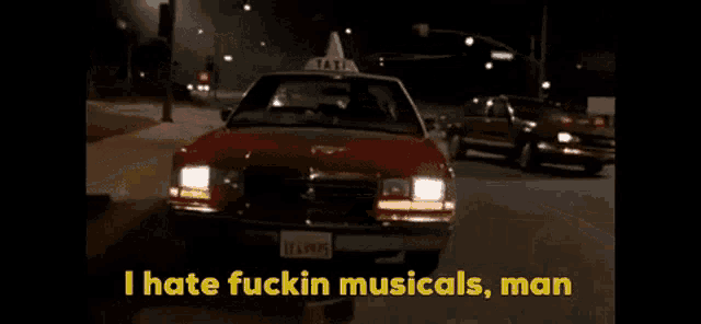 a taxi cab is driving down a street with the words " i hate fuckin musicals man " in yellow letters