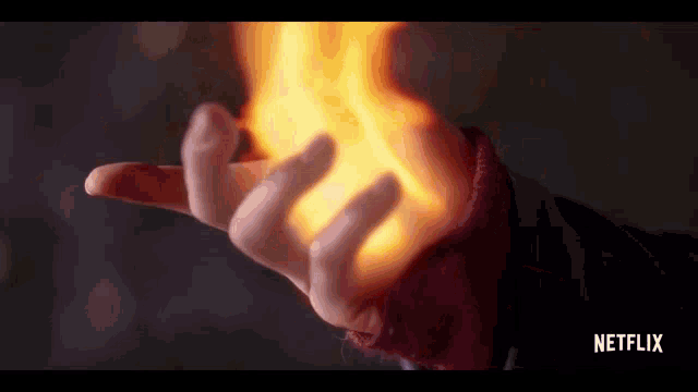 a close up of a person 's hand with fire coming out of it and the words netflix on the bottom