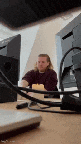 a man is sitting at a desk with a candle in front of a computer monitor .