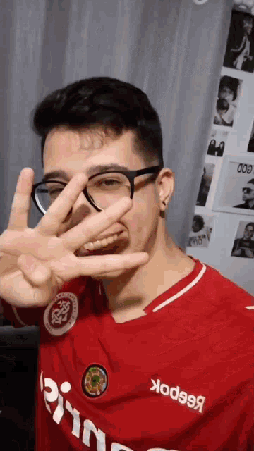 a man wearing glasses and a red shirt that says reebok