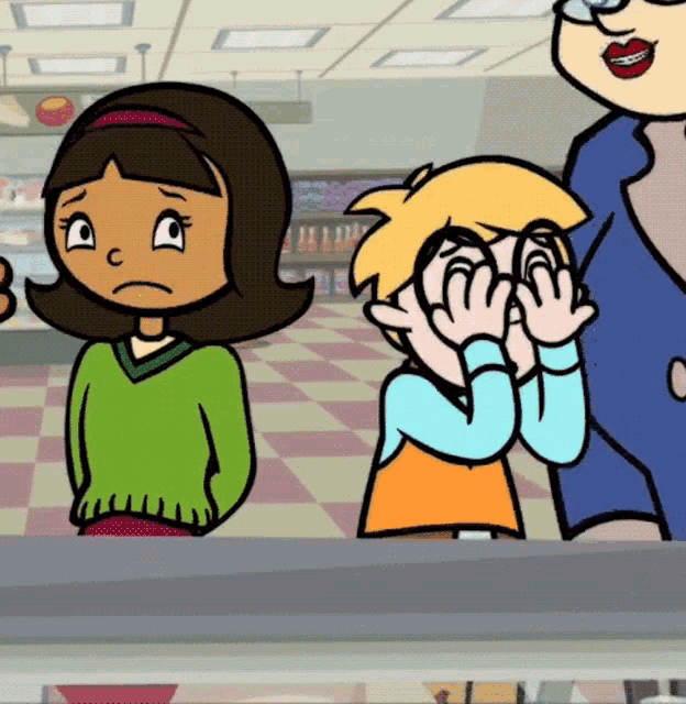 a girl in a green sweater is standing next to a boy who is covering his eyes with his hands