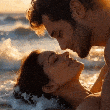 a man and a woman are kissing on the beach with their eyes closed