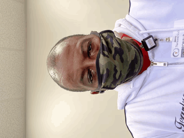 a man wearing a camouflage mask and a name tag that says ' neuroscience '