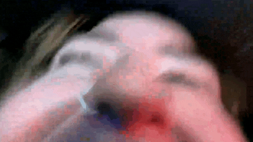 a blurry picture of a person 's face with a ring on their finger