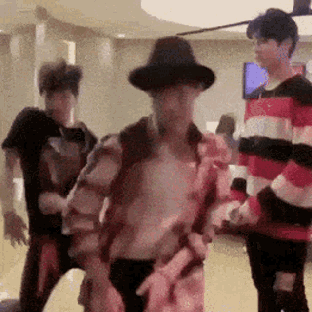 a group of young men are dancing together in a room .