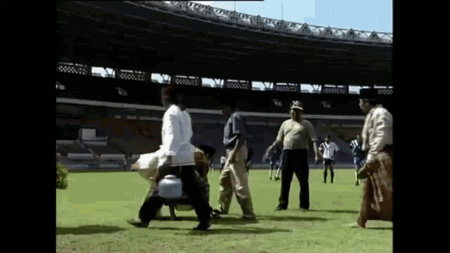 a group of men are walking on a soccer field .