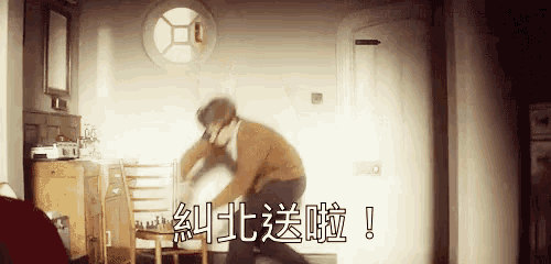 a man is standing next to a chair in a room with chinese characters on the wall .