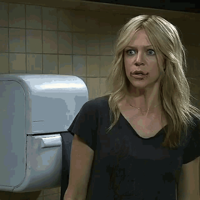 a woman standing in front of a paper towel dispenser