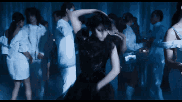 a woman in a black dress is dancing with a man in a white jacket