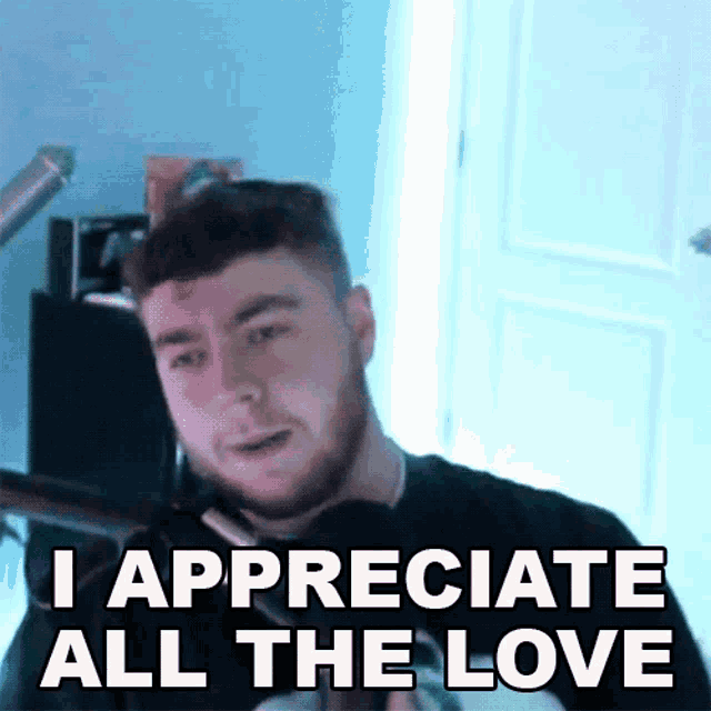 a man with a beard says i appreciate all the love in front of a microphone .
