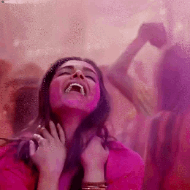 a woman with pink powder on her face laughs