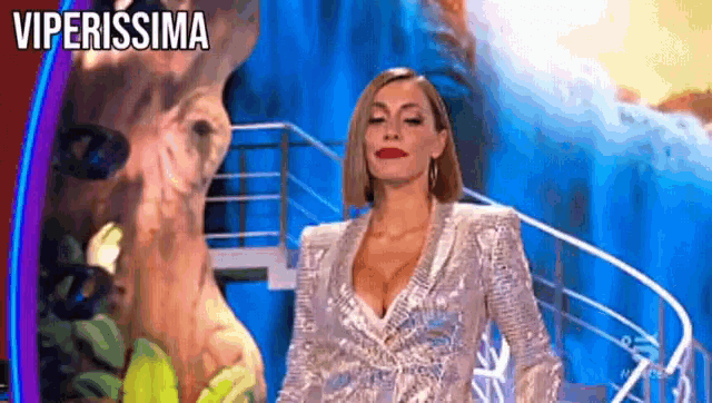 a woman in a sequined dress is standing on a stage in front of a kangaroo .