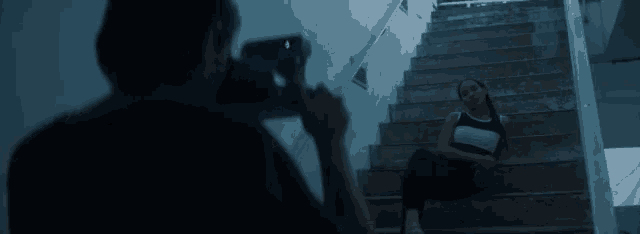 a man is taking a picture of a woman on the stairs