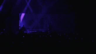 a man is standing on a stage with a microphone in his hand