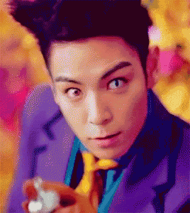 a man in a purple suit and tie is holding a bottle
