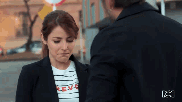 a woman wearing a t-shirt that says revo looks down