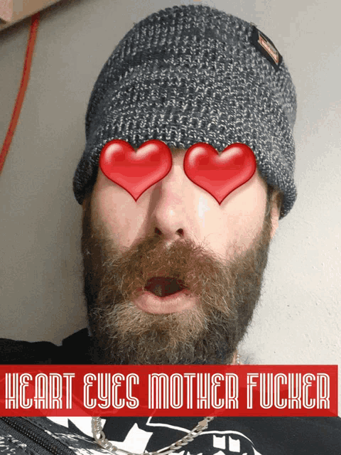 a man with a beard wearing a beanie with hearts in his eyes and the words heart eyes mother fucker below him