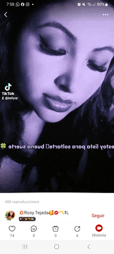 a screenshot of a woman 's face on a phone with a purple background