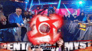 a man in a blue jacket stands in front of a crowd and a sign that says rent a fan upnext