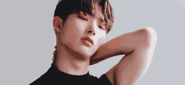 a young man with his hand on his neck
