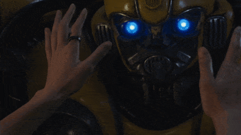 a close up of a person 's hand touching a transformer robot