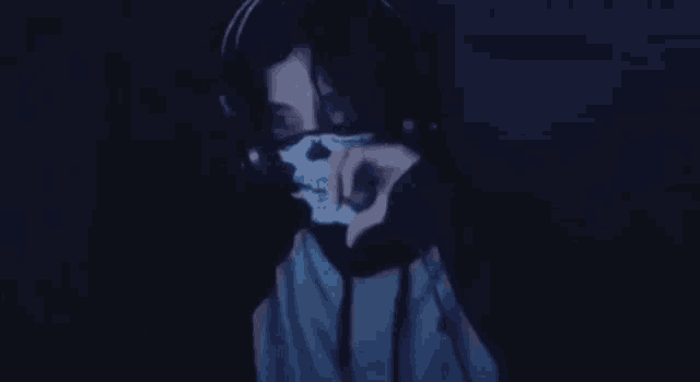 a man wearing headphones and a mask with a skull painted on his face .