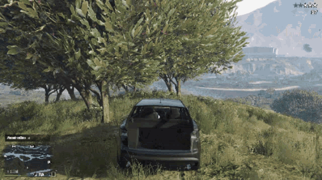 a video game screen shows a car parked in a grassy field with a tree and mountains in the background