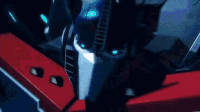 a close up of a red and blue robot with the letter l on it