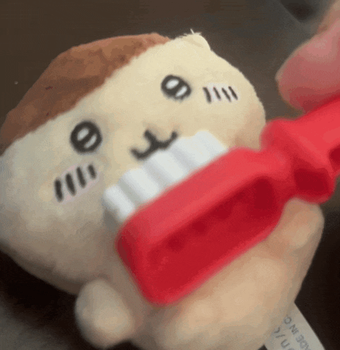 a stuffed animal with a red toothbrush in its mouth made in japan