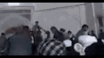 a group of people are dancing in a room .