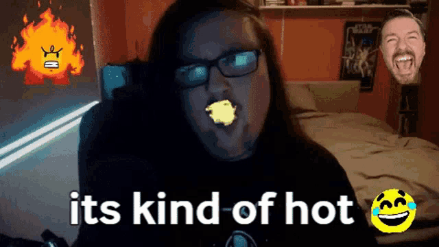 a man with glasses is eating a piece of food with the words " it 's kind of hot " behind him