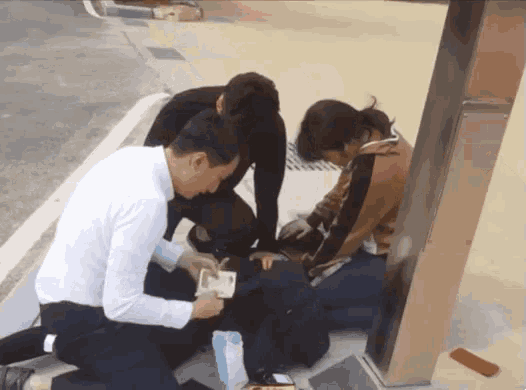 a man in a white shirt is kneeling down next to a woman in black