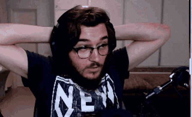 a man with a beard wearing glasses and a new york shirt