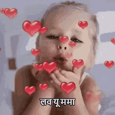 a baby is blowing a kiss with hearts surrounding him .