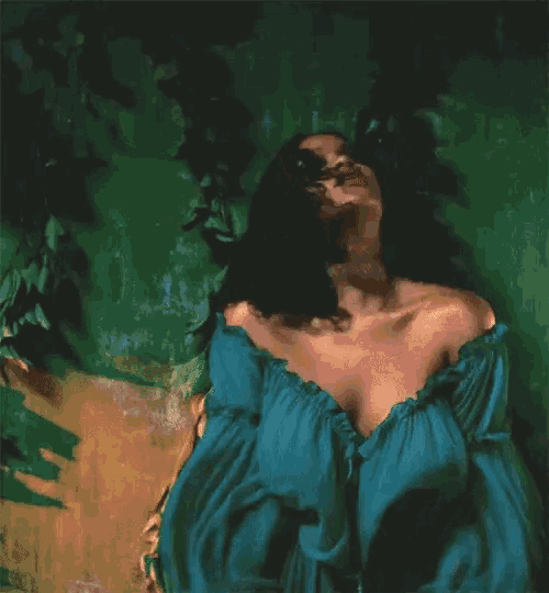 a woman in a blue dress is laying on a green wall surrounded by trees .