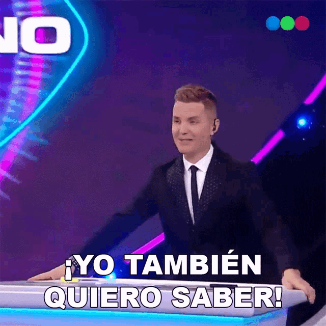 a man in a suit and tie is standing in front of a podium and says yo tambien quiero saber