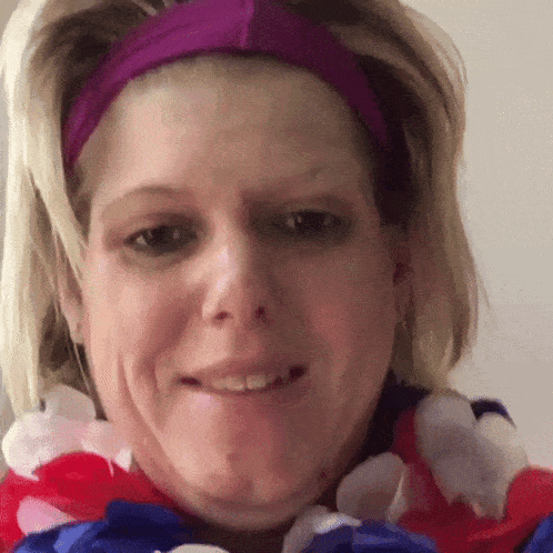 a woman is wearing a purple headband and a red white and blue lei