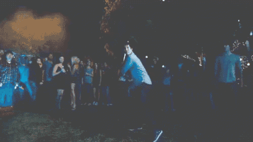 a man is holding a bat in front of a crowd of people who are watching
