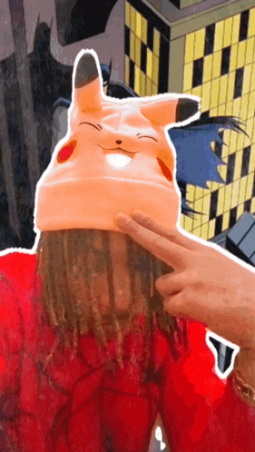 a person wearing a pikachu hat with a batman behind them