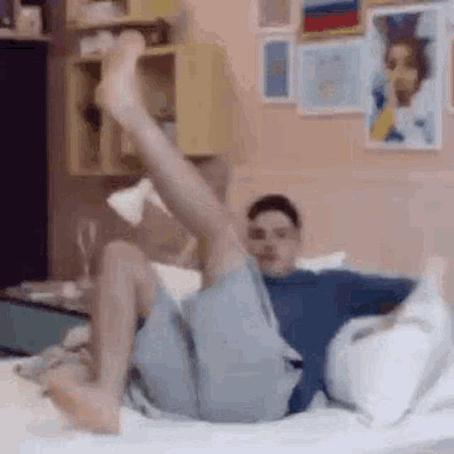 a man is laying on his stomach on a bed with his legs in the air .