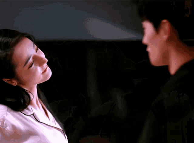 a man and a woman are looking into each other 's eyes