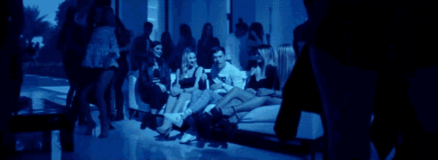 a group of people are sitting on a couch in a room