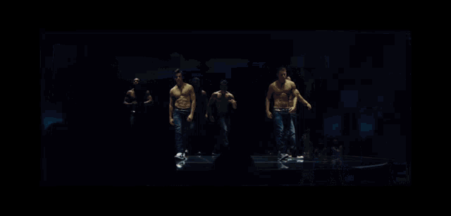 a group of men without shirts are dancing on a stage